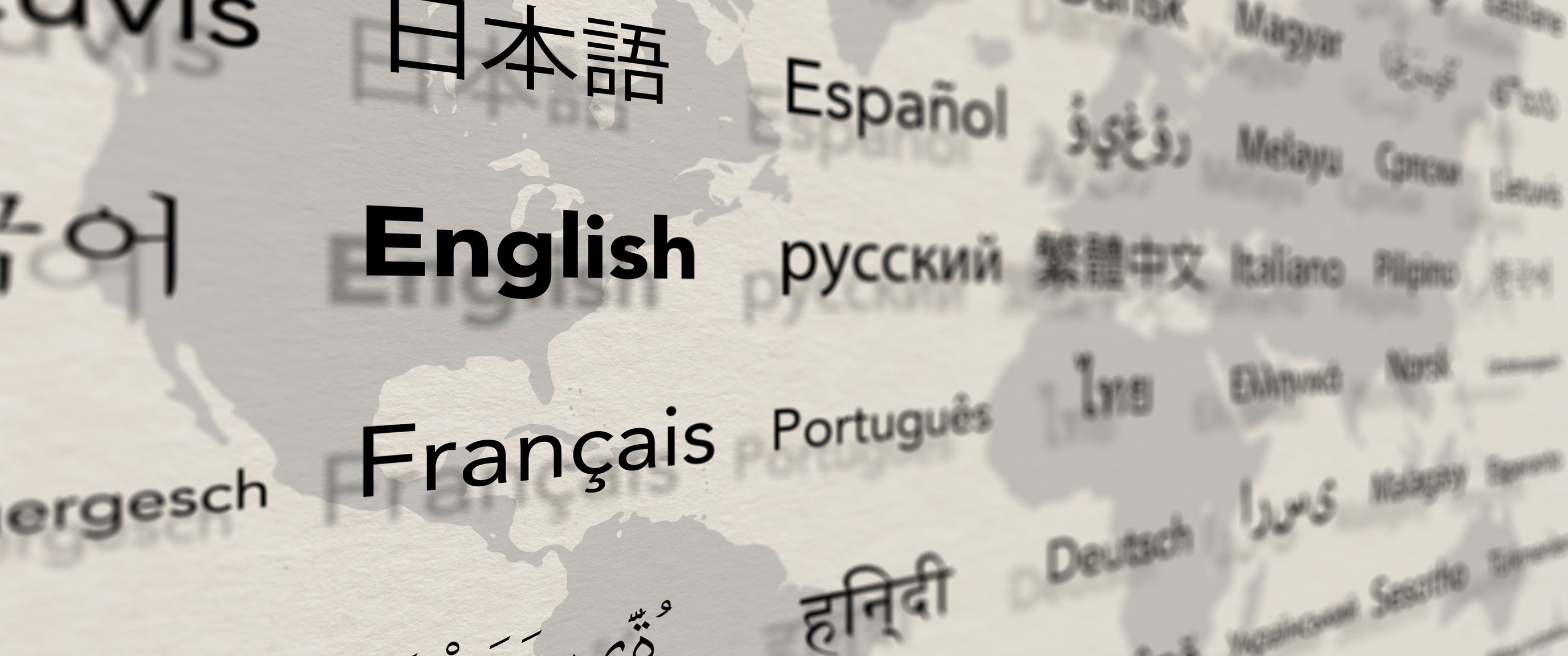 Several important languages on paper with world map background.